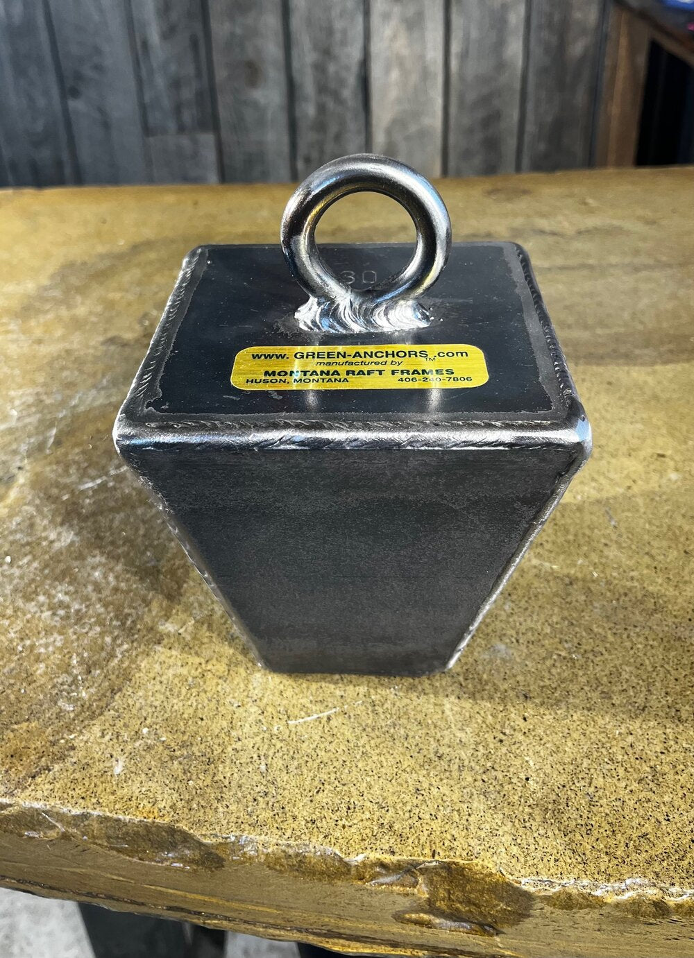 Green Anchor steel encased lead pyramid anchor by Montana Raft Frames shown on textured surface at Freestone Fly Shop